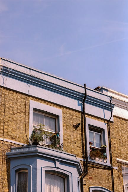 A street scene in Fulham featuring a row of elegant, multi-storey residential buildings with large windows and decorative balconies. The pavement is populated with a few pedestrians, while several par